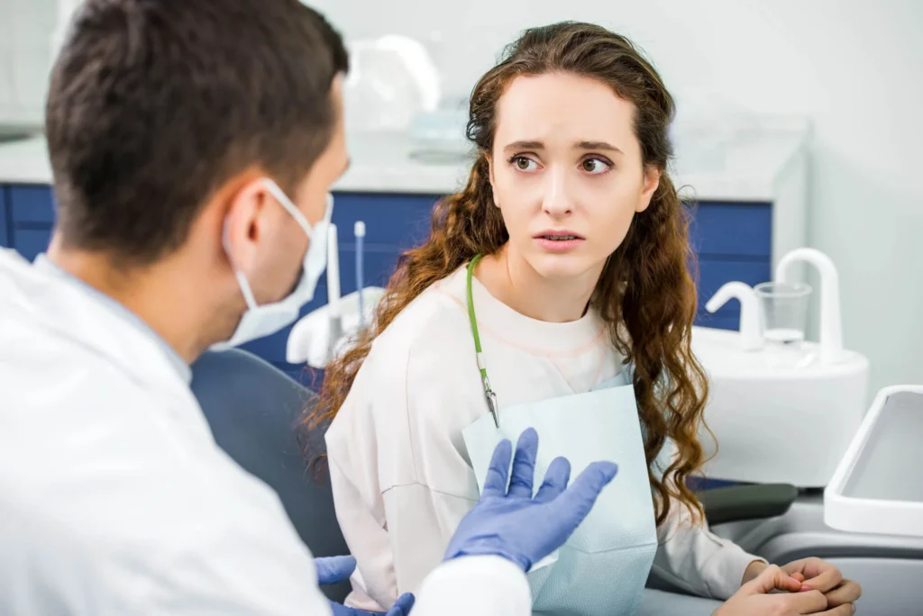 A worried looking patient is looking at an emergency dentist in Franklinville, NJ